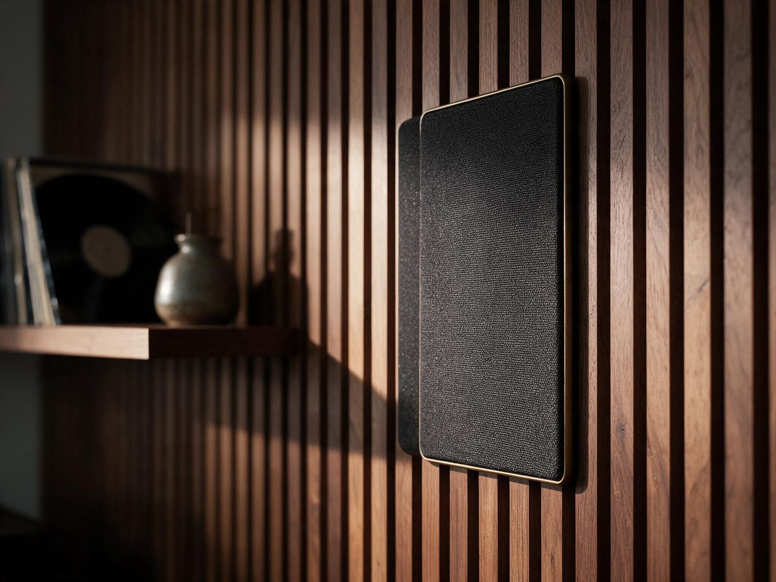 In-wall speaker in a walnut slat wall